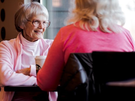 old woman at a caffe talking to another woman