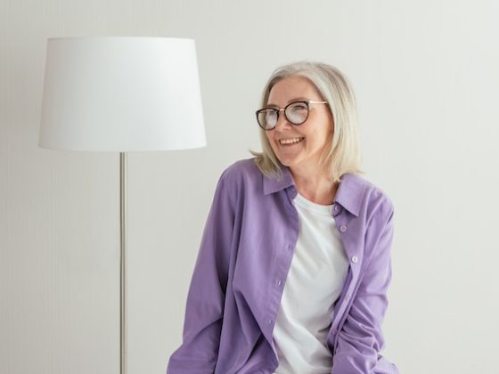 Woman sitting next to a lamp and smiling