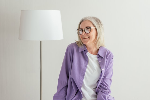 Woman sitting next to a lamp and smiling