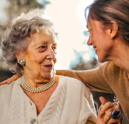 Older woman and younger woman holding hands