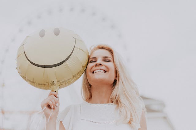 a-smiling-woman-holding-a-balloon-for-green-light-therapy-for-depression